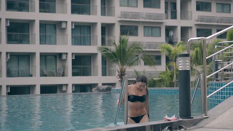 young-lady-in-swimsuit-goes-up-pool-stairs-slow-motion