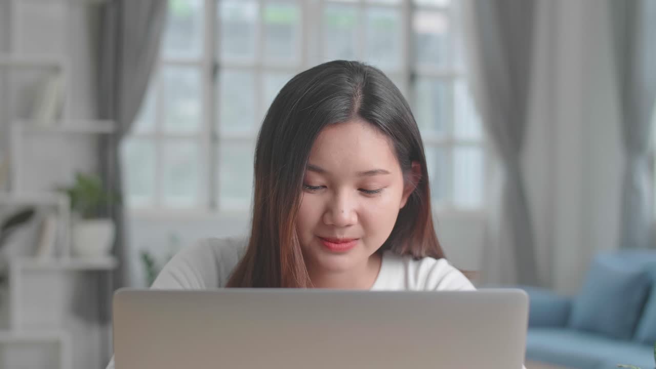 Close Up Asian Girl Typing On Computer Keyboard Of A Laptop And Smiling At Home, Video In 4K
