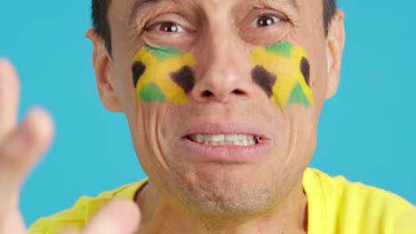 very nervous man supporting jamaican team during a difficult match