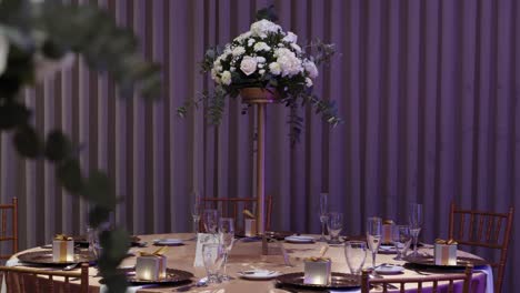 mesa de banquete redonda para invitados a la boda decorada con flores frescas y cubiertos de cristal
