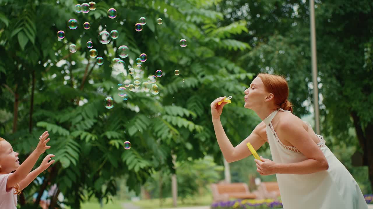 Mother and Daughter Playing with Bubbles in the Park