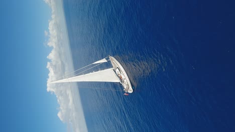 fpv vertical flight around luxury sailing yacht on blue caribbean sea during sunlight