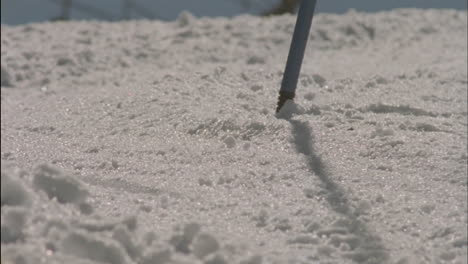 a skier races down a slope past a slalom pole