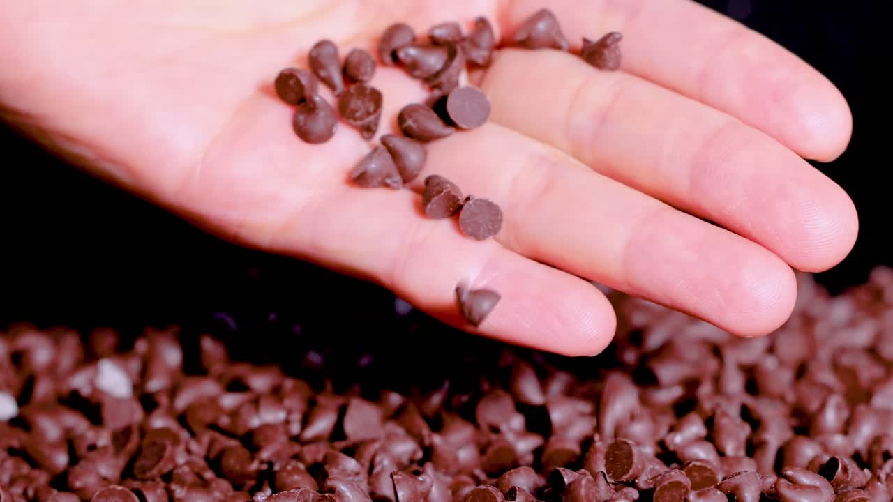 una mano libera gradualmente las fichas de chocolate