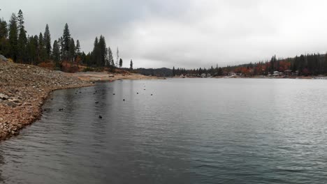 low aerial shot of rocky lake shore on a cloudy day