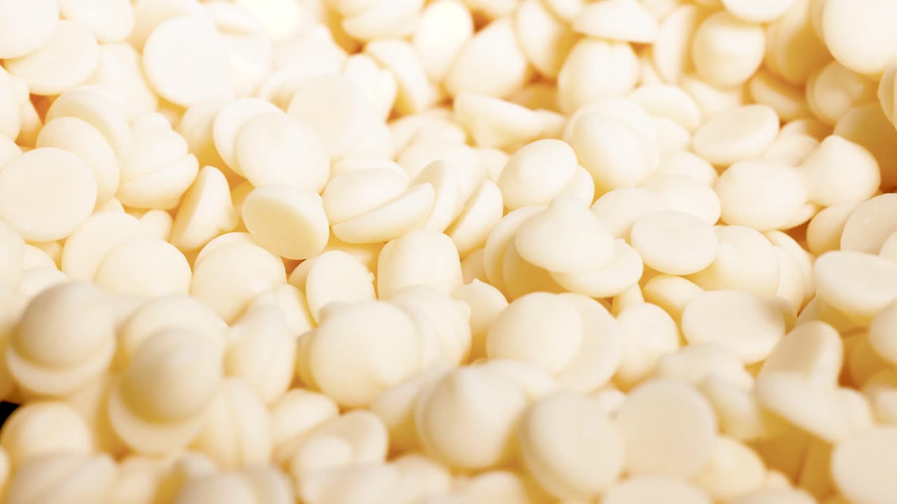 Spoon scooping white chocolate chips repeatedly