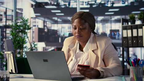 mujer pagando la factura en la computadora portátil en la oficina