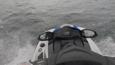 foto de un motociclista haciendo altas velocidades a través de un océano agitado en newquay