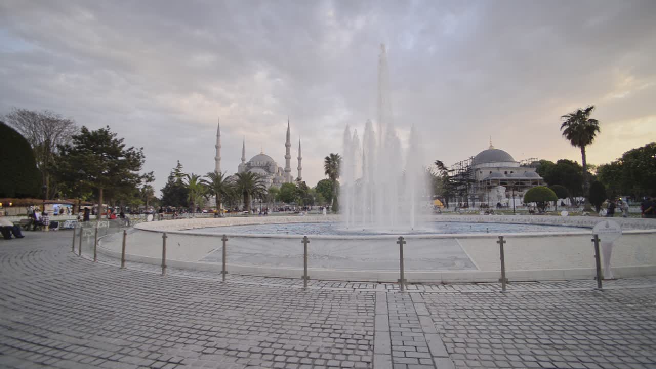 View of the Blue Mosque, behind fountains, Istanbul, Turkey, on a cloudy evening