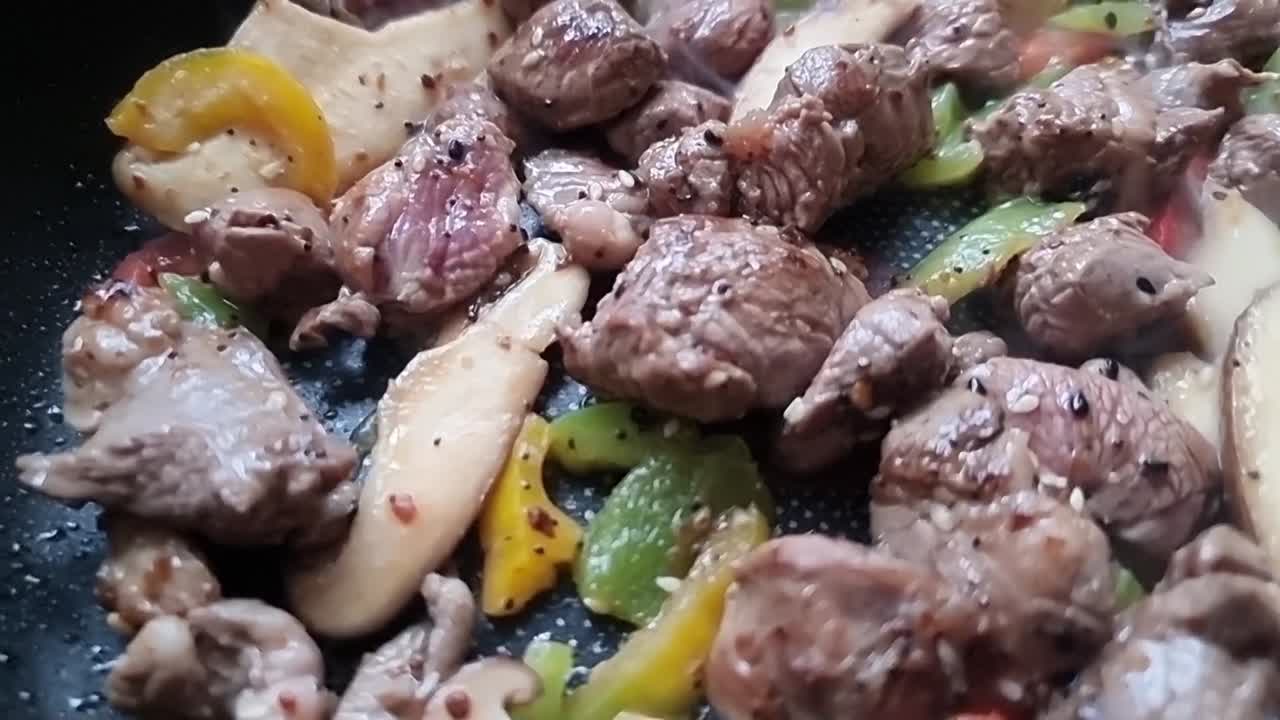 Gambar dekat semur daging domba dadu berbumbu Maroko yang sehat, mendidih panas dalam wajan mengepul.