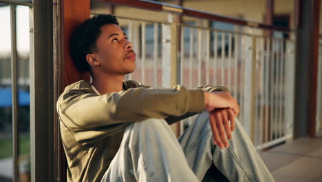 a contemplative teenager sitting alone on a balcony