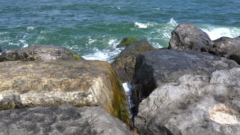 the ocean waves breaking in the rock jetty