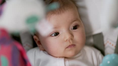 close-up front view of a pretty baby girl swinging in a swing