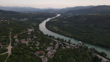 drone view of pocitelji castle and historical mosque on the river bank near mostar, bosnia and herzegovina