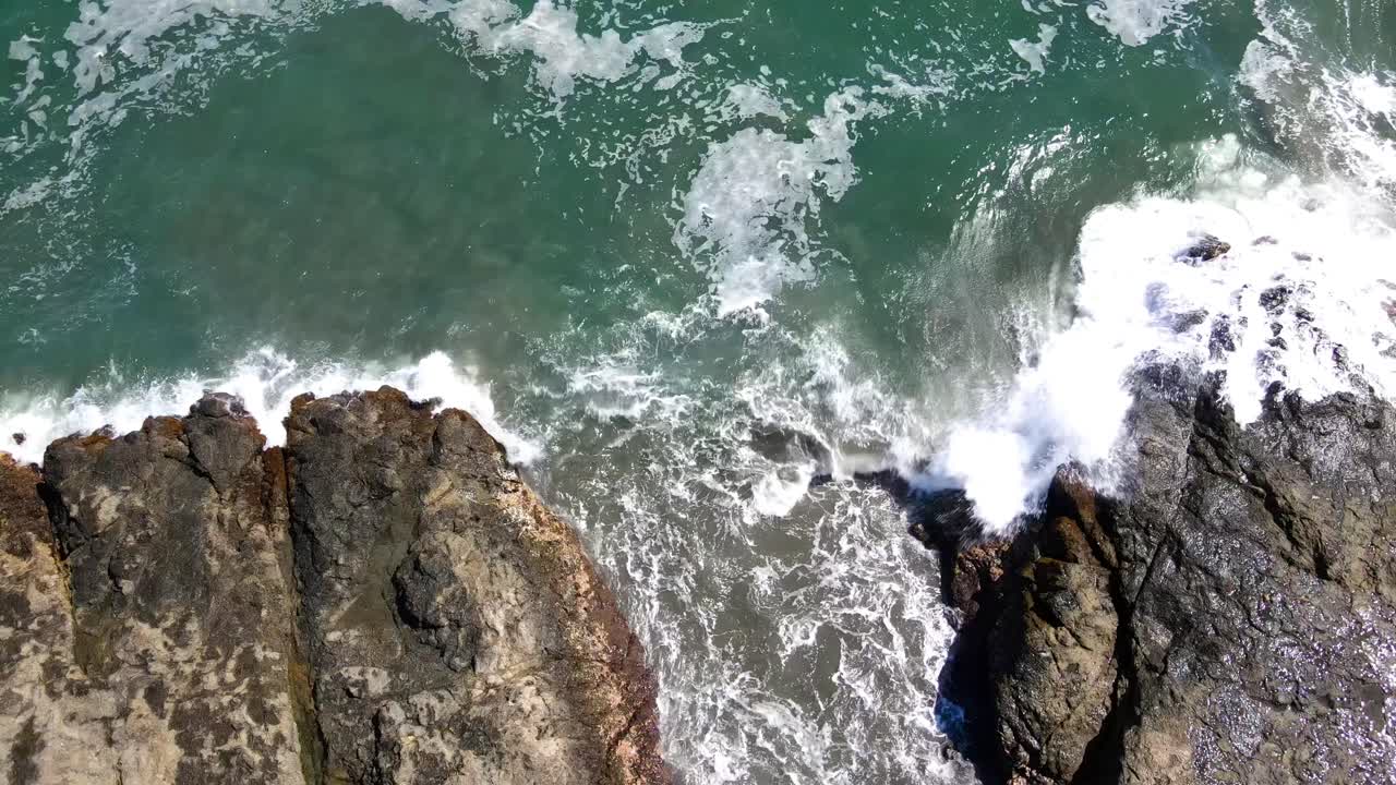 costa de piedra rocosa con olas salpicando contra las piedras drone shot dji, filmado en costa rica