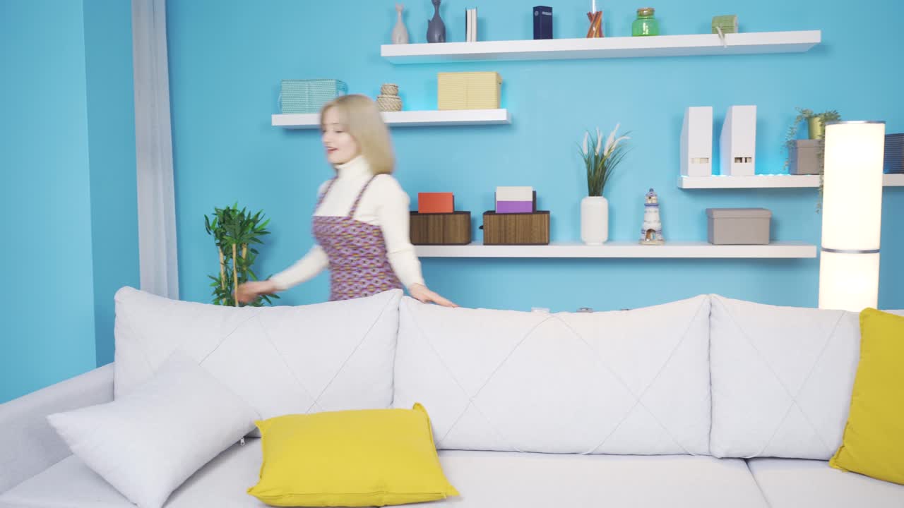 집에서 집을 정리하고 거울을 보는 행복한 여성.