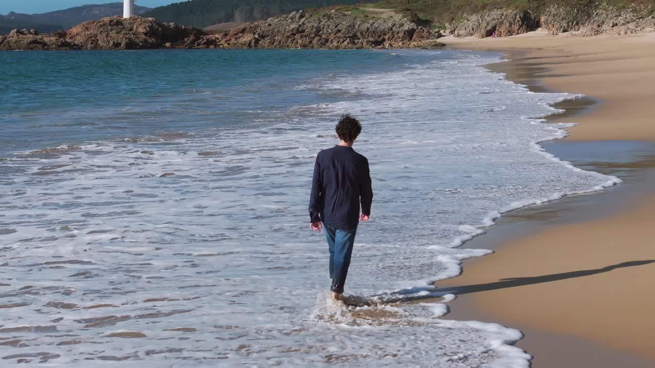 Couple Holding Hands While Walking At The Beach In Summer. - aerial shot