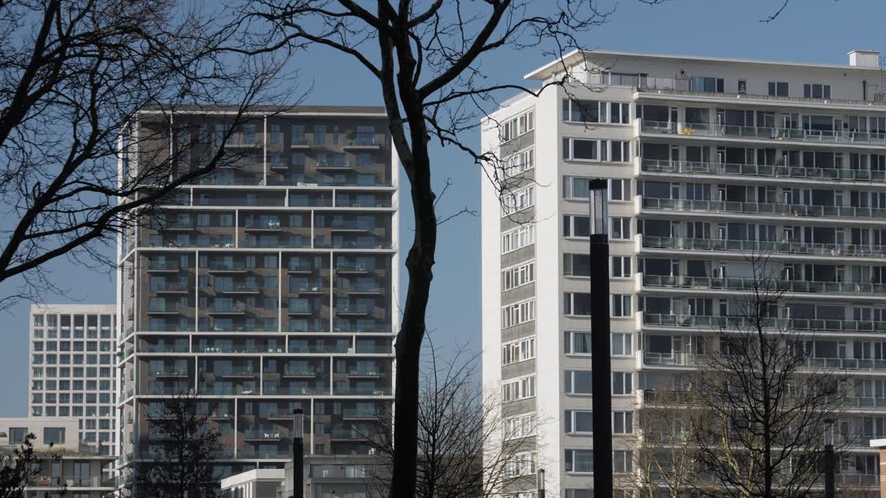 Old high-rise residential building stands next to modern apartment towers in Nieuw-Zuid, Antwerp, highlighting urban development and contrast in architecture