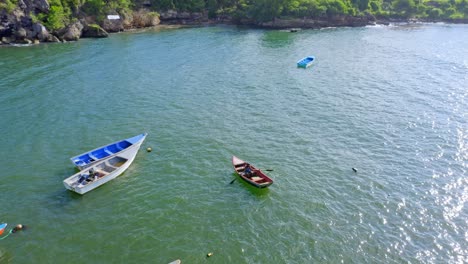 Aerial-top-down-shot-of-fishing-boats-in-Boca-de-Yuma-Coastline-during-summer-day-on-Dominican-Republic-Island---Fisherman-sitting-in-fishing-boat