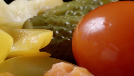 close-up video of rotating pickled vegetables on black background