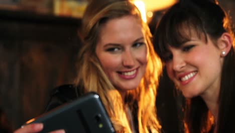 two beautiful women taking selfie on mobile phone