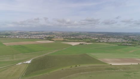 aerial tracking north from maiden castle, the towns of dorchester and poundbury is visible in the background