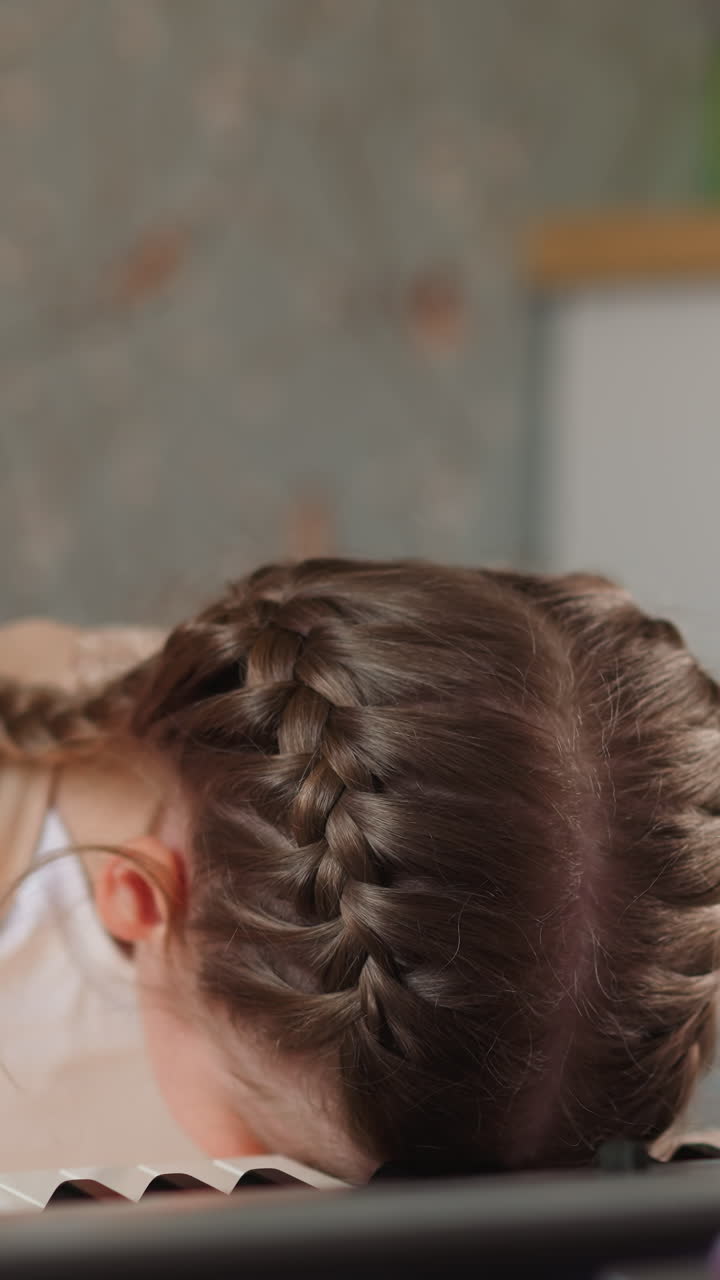 Tired schoolgirl in orthopedic corset rests head on piano keyboard. Exhausted girl needs relaxation after playing complicated music closeup on blurred background