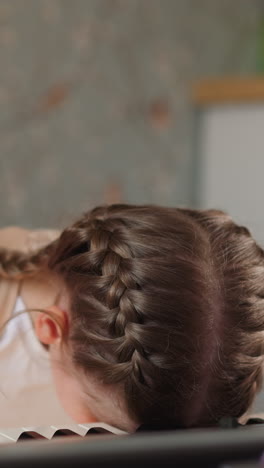 tired schoolgirl in orthopedic corset rests head on piano keyboard. exhausted girl needs relaxation after playing complicated music closeup on blurred background