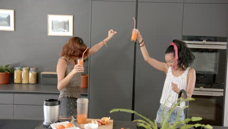 two young biracial female friends enjoy a playful moment in a modern kitchen