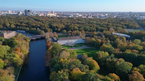 schloss bellevue palace nestled among vibrant autumn foliage in tiergarten park, berlin, germany. magic aerial view flight fly reverse drone