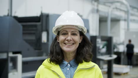 front view of smiling female technician looking at camera