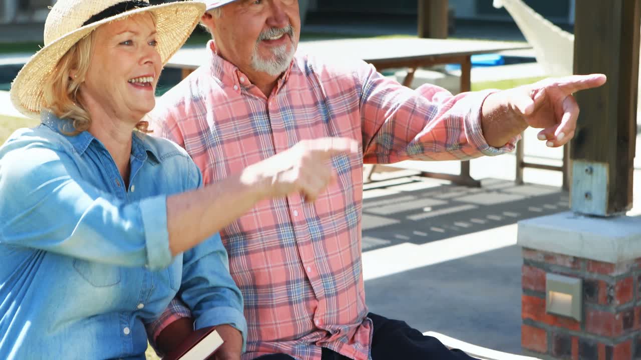 시니어 커플 이 멀리 를 가리키고 있다