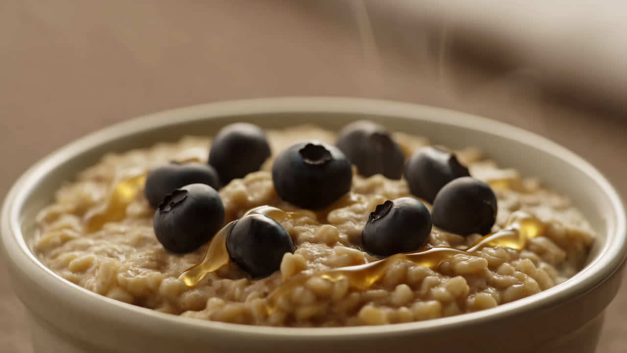 Ciotola di farina d'avena con mirtilli e miele, porridge caldo e cremoso irrorato con miele dorato, morbida luce mattutina