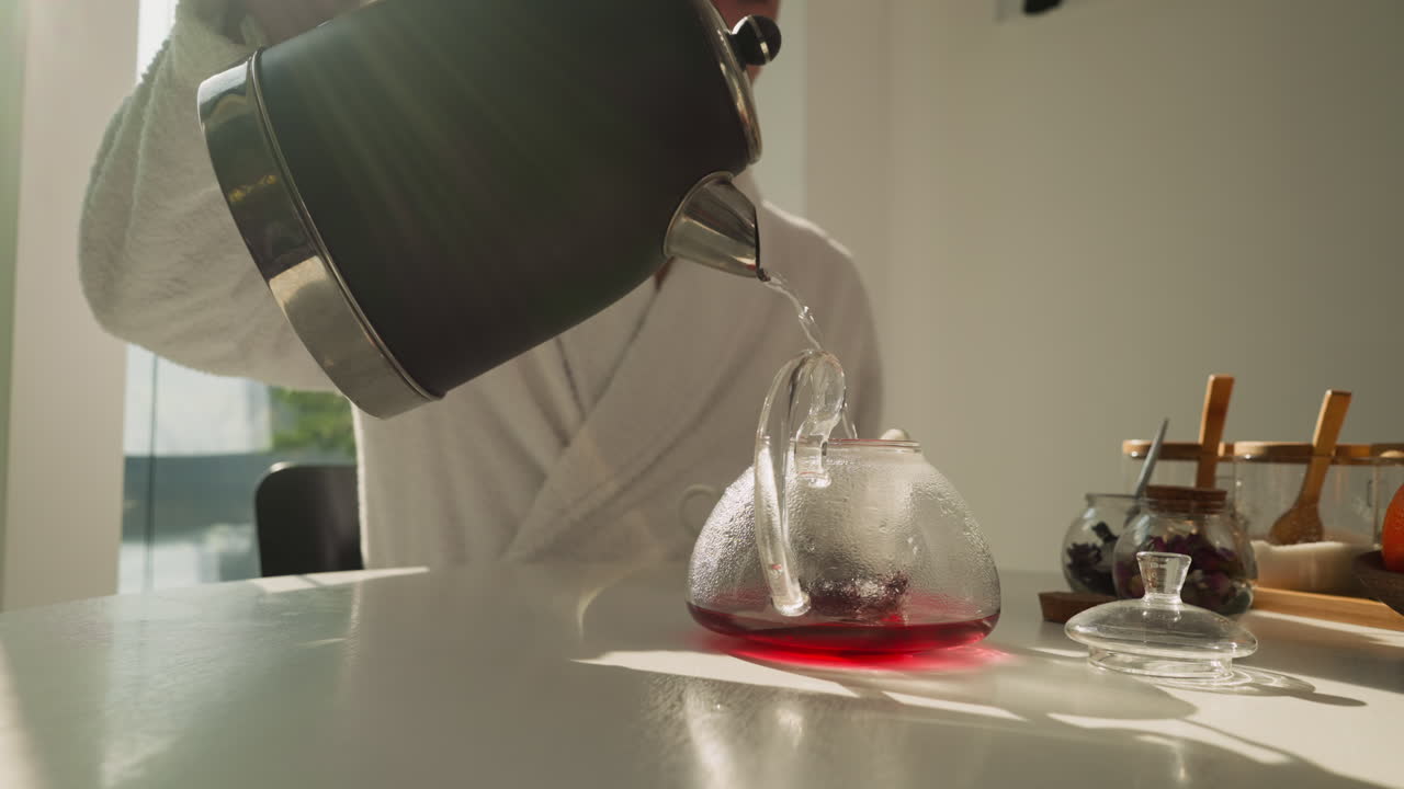 남자는 풀려있는 차 잎 위에 차병을 물로 채운다. 남자친구는 자연 풍경을 고려하여 증기 음료를 만든다. 철저한 양조 과정