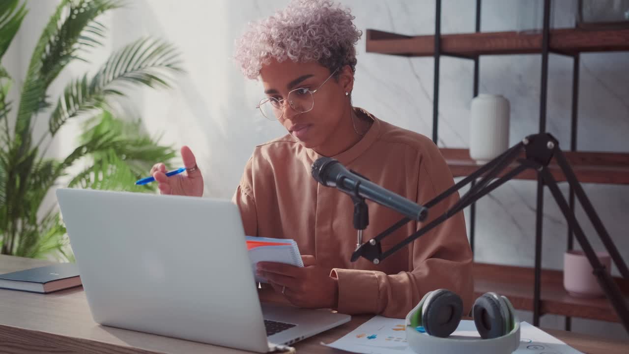 Carried away african american woman talking and making notes in notebook