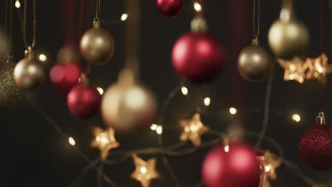 video of gold and red christmas baubles decorations with copy space on black background