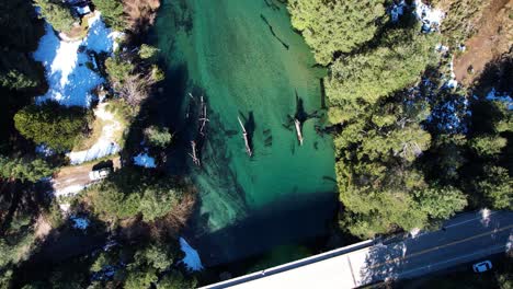 New-highway-bridge-and-remains-of-old-one-in-middle-of-river,-aerial-top-down-view