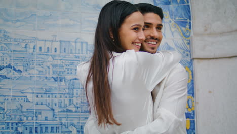 smiling sweethearts embracing tile wall vertical close up. lovers romantic date