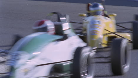 four racing cars race around a track