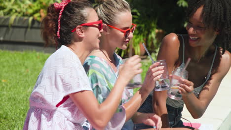 enjoying sunny day by pool, diverse female friends wearing sunglasses and smiling