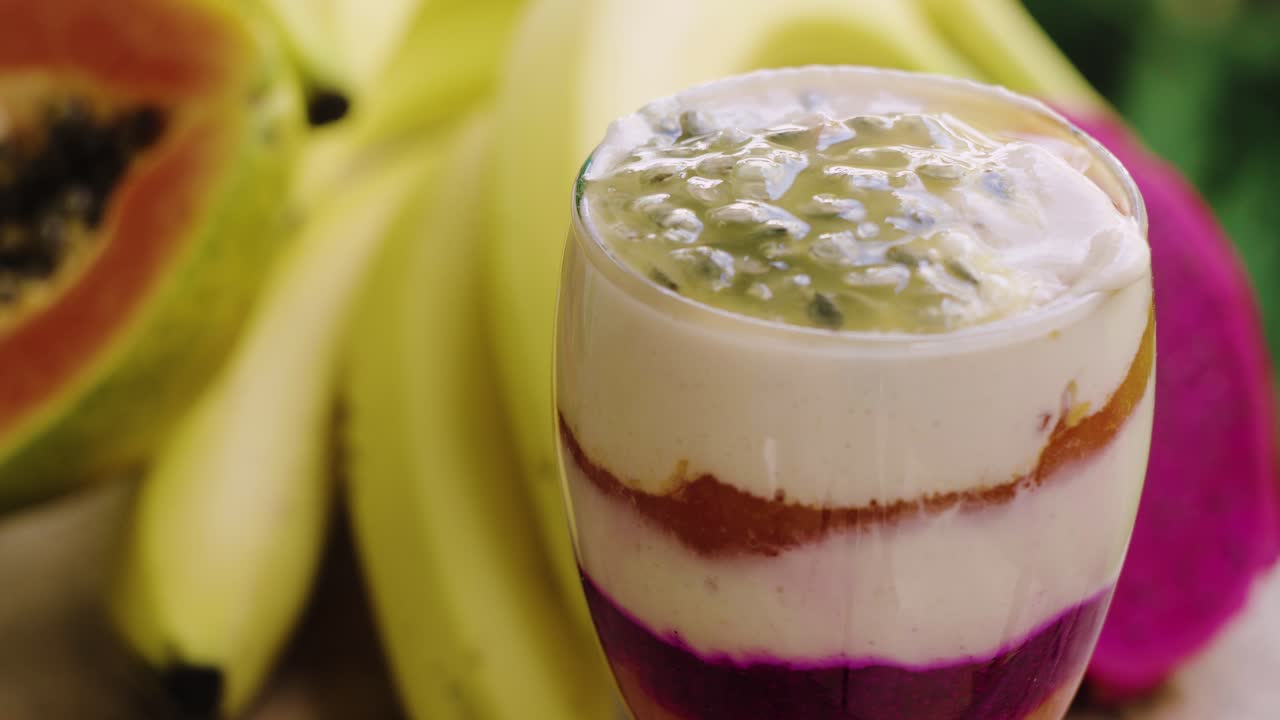 Primo piano di frullato esotico con banana, papaya, frutto del drago e frutto della passione.