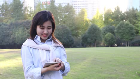 4k: hermosa mujer asiática escuchando música bajo el sol en un parque, shanghai, china