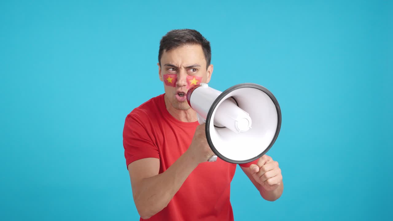 Excited man with vietnamese flag on face using a megaphone
