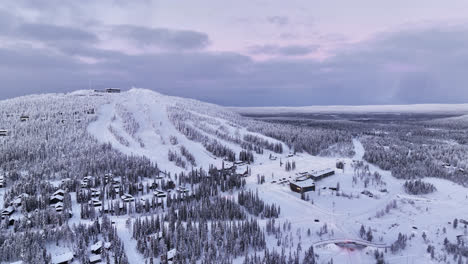 vista aérea acercándose al centro de esquí iso-syote, vibrante noche de invierno en finlandia