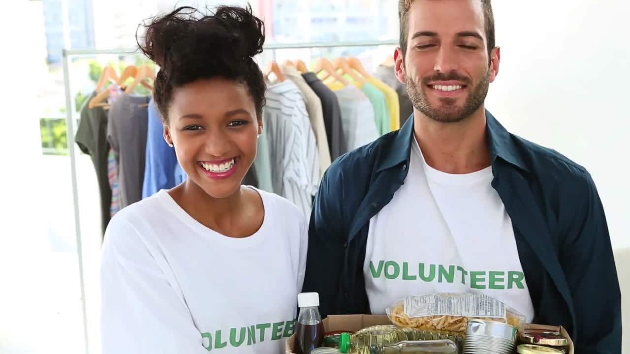 Happy volunteer team holding a food donation box