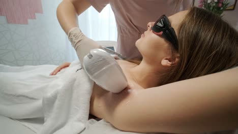 depilación láser - procedimiento de depilación. flash de depilación láser de diodo, esteticista elimina el pelo en hermosas piernas femeninas, depilación para piel lisa, procedimiento láser en un estudio de belleza o clínica, tratamiento de depilación para el cuidado del cuerpo.