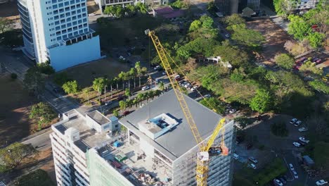 Aerial-orbit-of-the-top-part-of-crane-and-building-rooftop-under-construction-in-scenic-Philippine-city-during-daytime