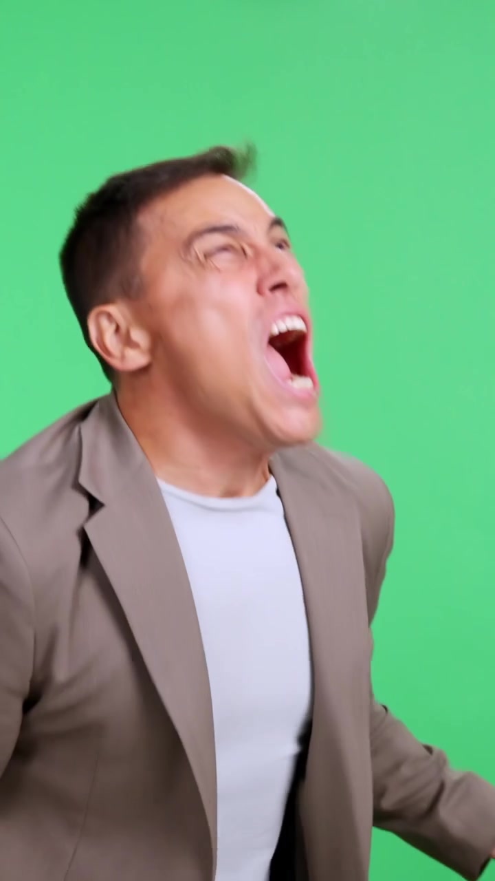 Stressed businessman shouting against green screen