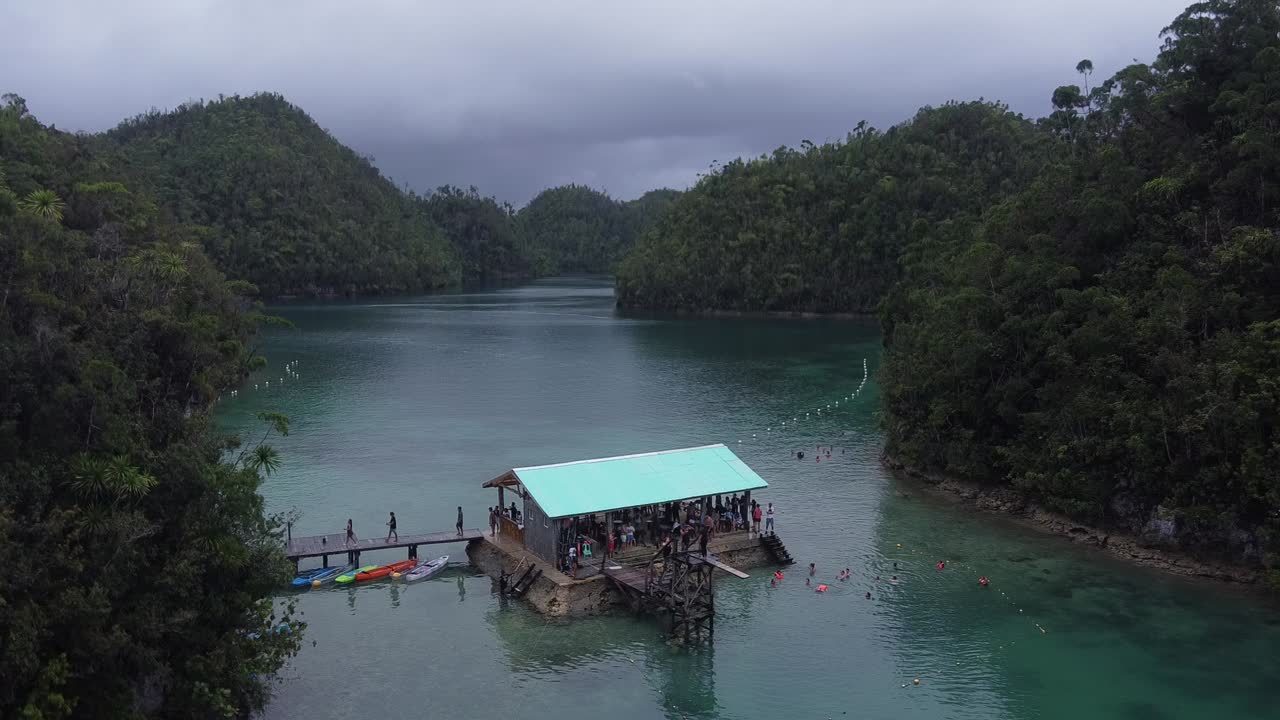 aerial, turistas nadando por una cabaña flotante de estilo pontón de la laguna de sugba en la isla de siargao, filipinas