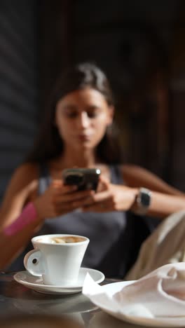 mujer usando el teléfono en un café